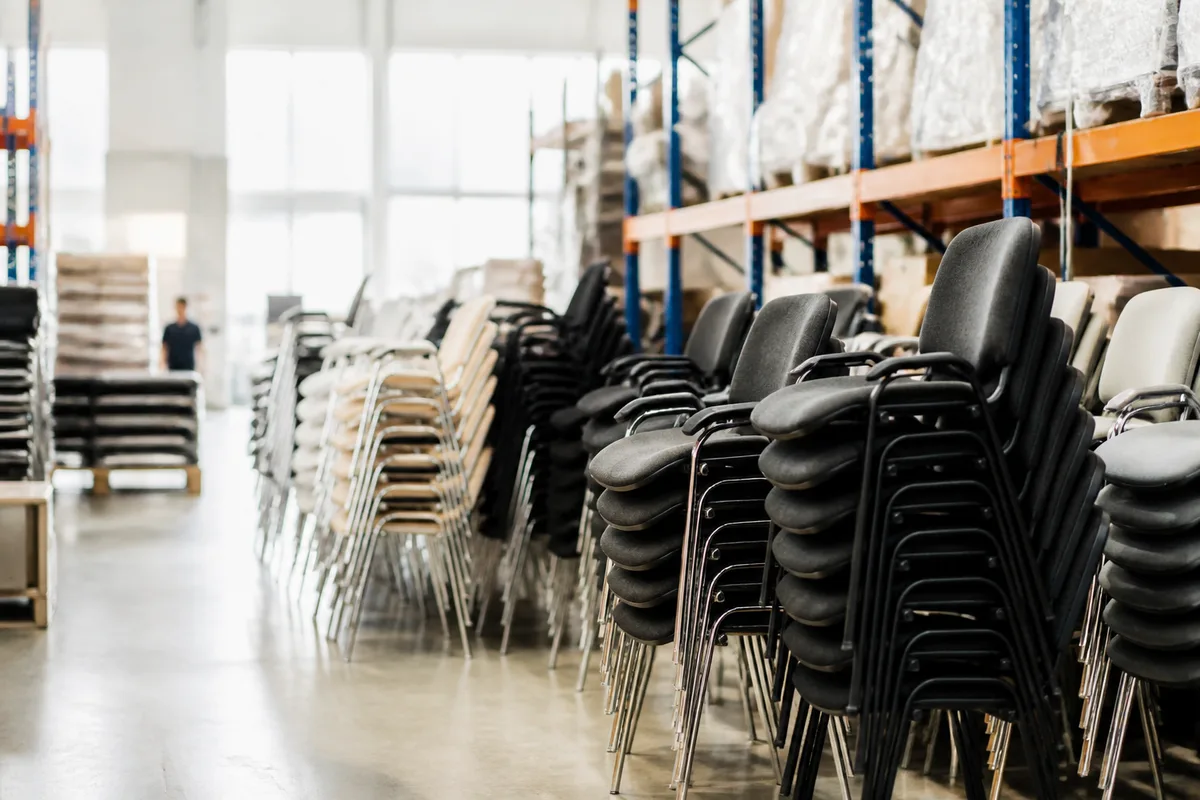 Chaises professionnelles empilées dans un entrepôt de stockage lumineux